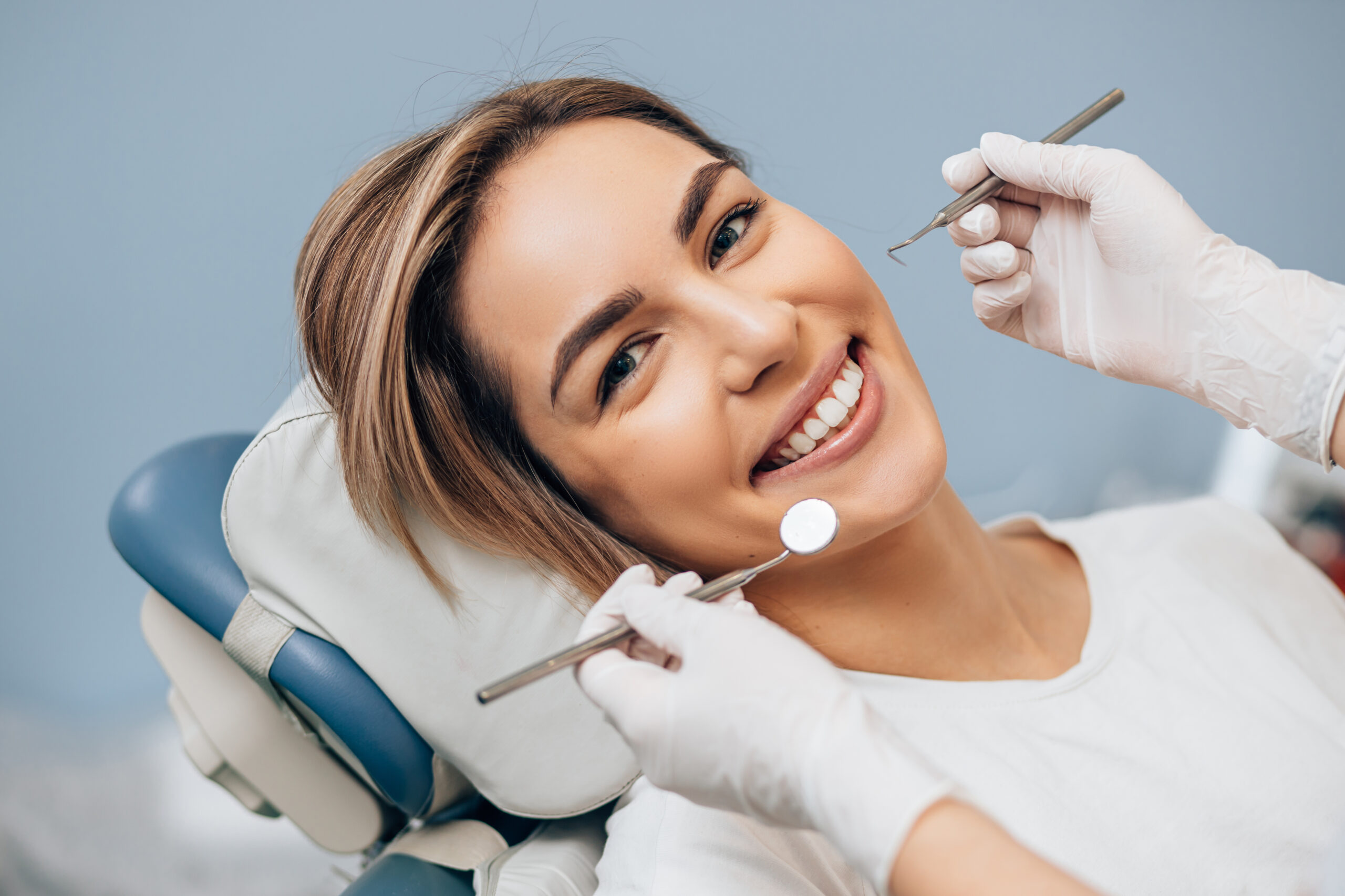 portrait of young caucasian woman with perfect smile in dental office