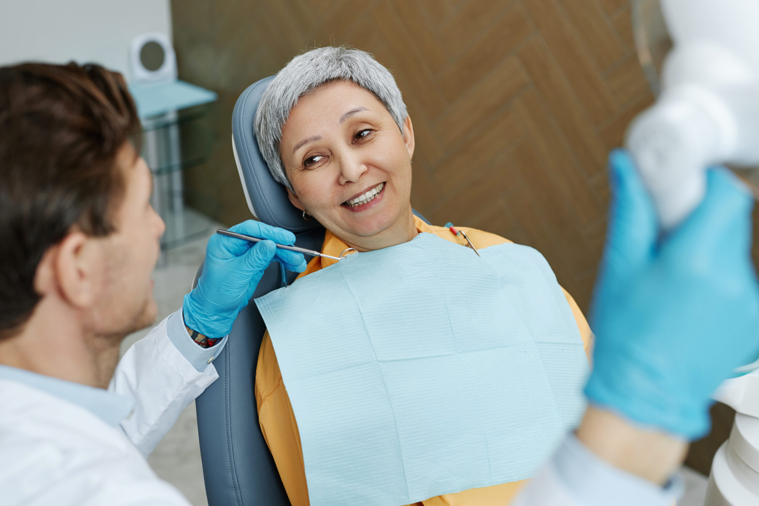 elderly woman smiling at the dentist wearing her dentures